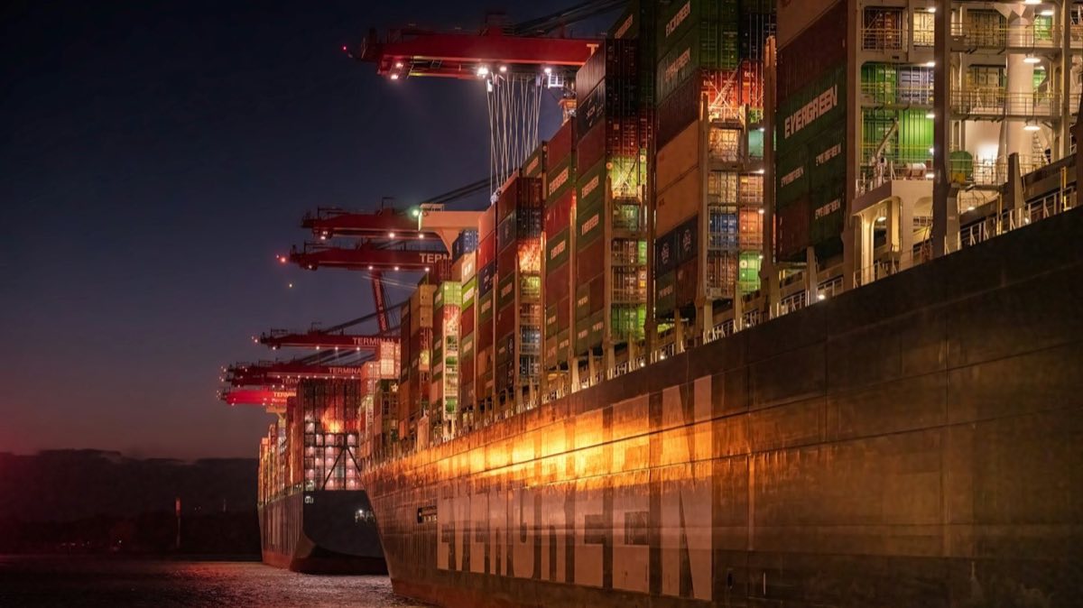 A container ship loaded alongside a quay under floodlights at night
