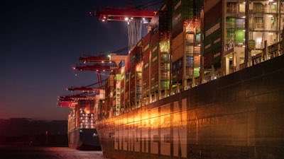 A container ship loaded alongside a quay under floodlights at night