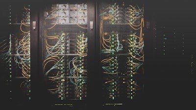 Rows of server racks in a data centre with patch cables running between them
