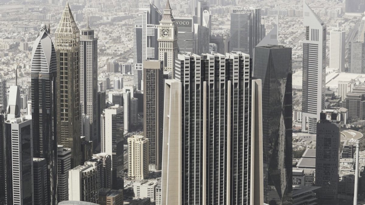 Modern high-rise towers of a financial district against a hazy sky