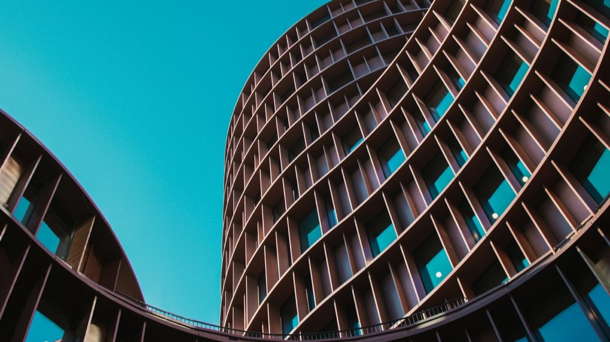 The curved facade of a modern institutional building seen from below
