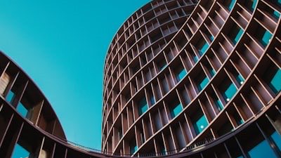 The curved facade of a modern institutional building seen from below